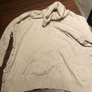 Tan turtleneck sweater with buttons on the sides